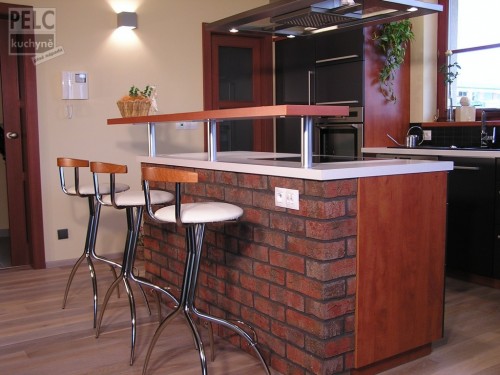 Bar vycházející z ostrůvku, který je obložen cihlami.