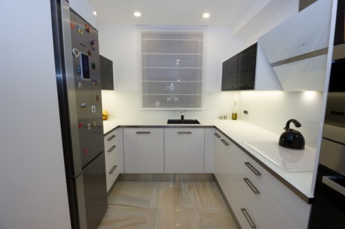 V kuchyni je skleněná pracovní deska s nerezovým designovým rámečkem