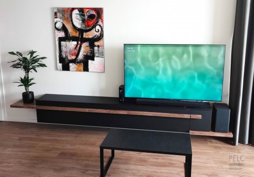 Pohled na zakázkový TV nábytek s konferenčním stolkem inspirovaný designem kuchyně.