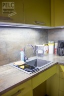 Barevně sladěný granitový dřez, pracovní deska a zástěna kuchyně.