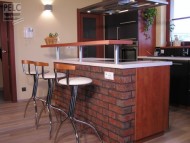 Bar vycházející z ostrůvku, který je obložen cihlami.