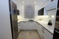V kuchyni je skleněná pracovní deska s nerezovým designovým rámečkem