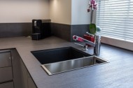 Kompaktní deska umožňuje zabudovat dřez se spodní montáží. Na obrázku je pěkně vidět toto provedení. Pro kávovar je malá elektrická zásuvka přímo za spotřebičem. 